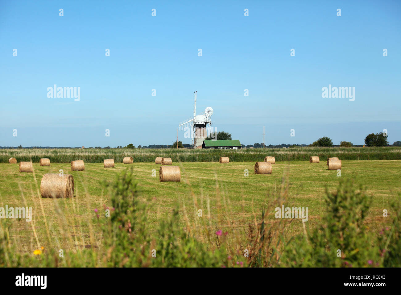 Round bales and windmill Stock Photo - Alamy