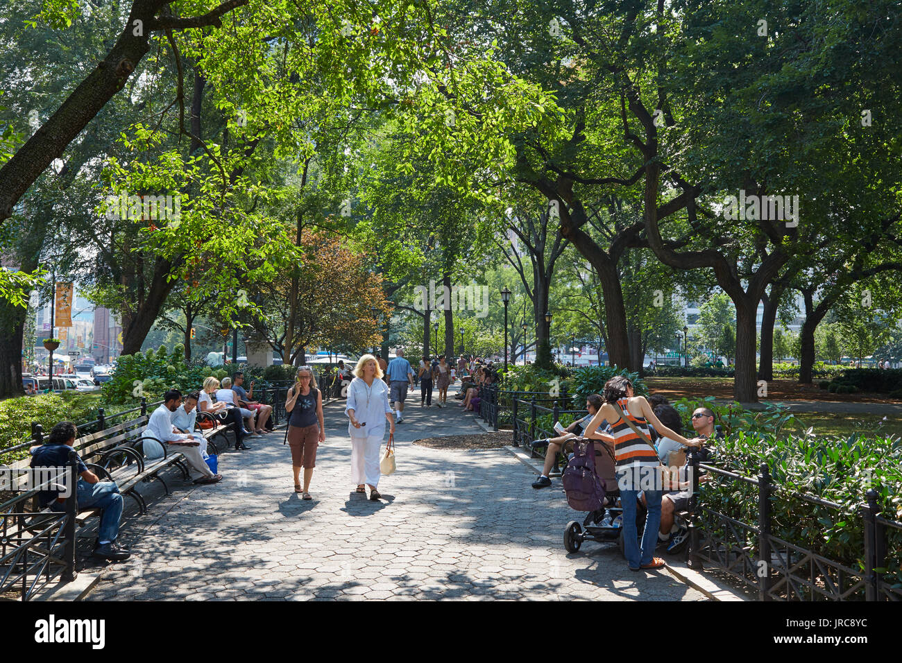 Union Square garden with people walking and sitting on benches in a sunny day in New York Stock Photo