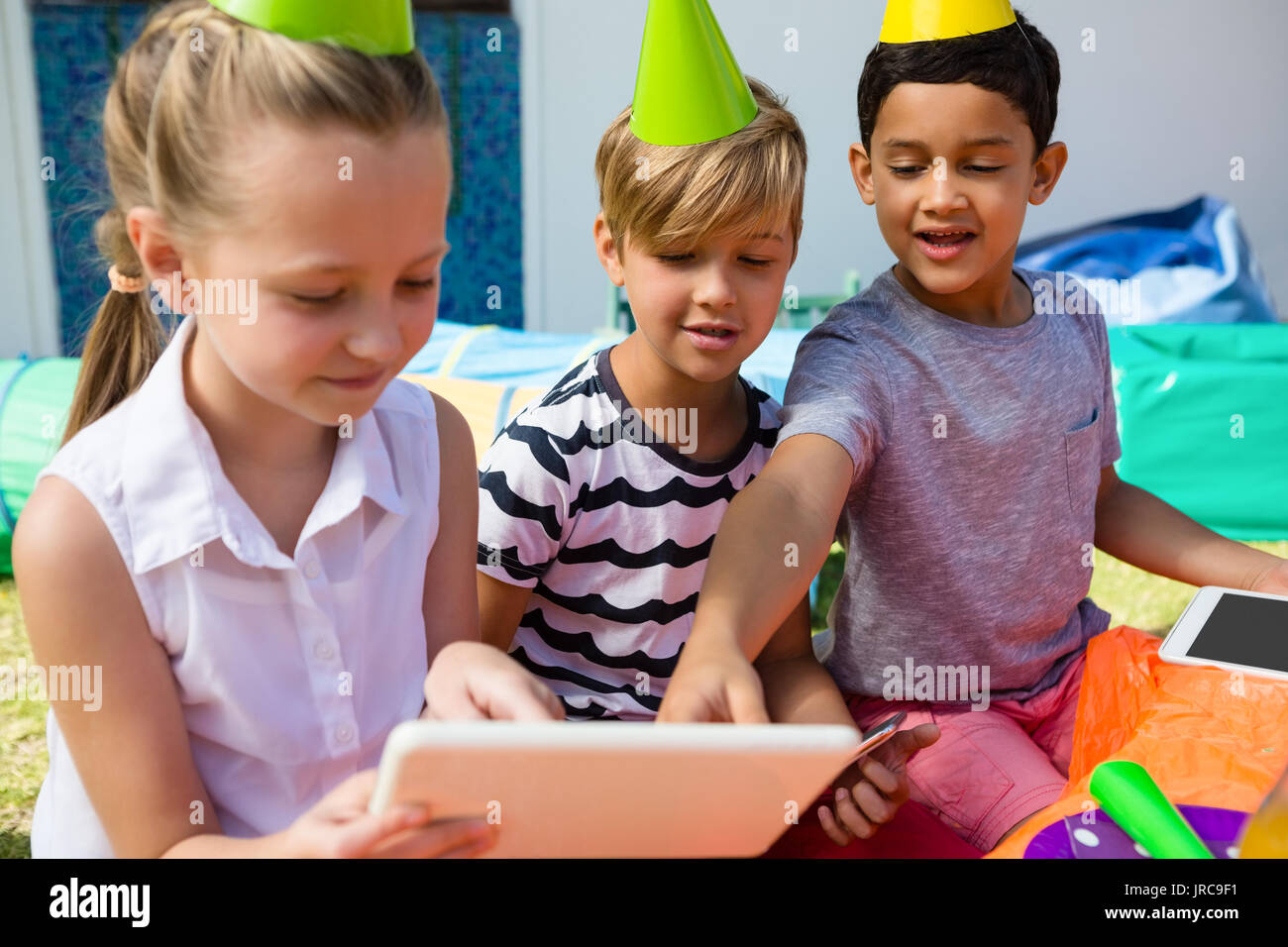 Children using digital tablet during birthday party in yard Stock Photo