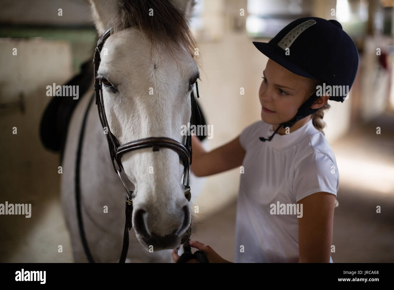 Teenage girl standing with horse in the stable Stock Photo - Alamy