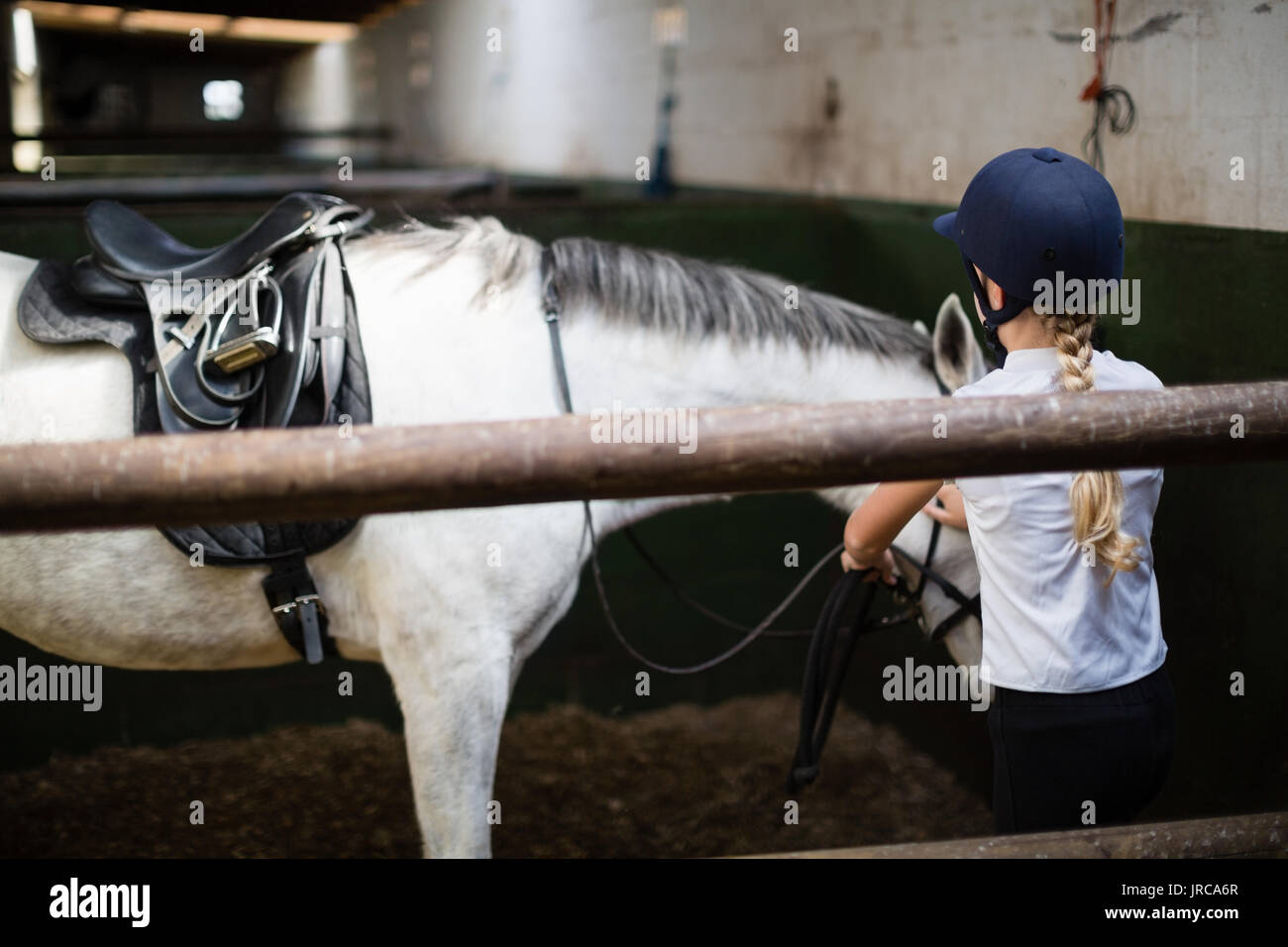 Teenage girl standing with horse in the stable Stock Photo - Alamy
