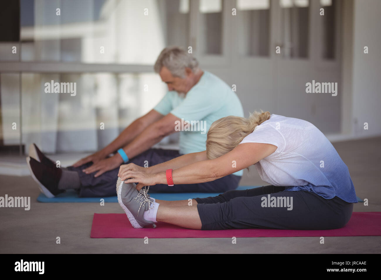 Senior couple performing stretching exercise at home Stock Photo - Alamy
