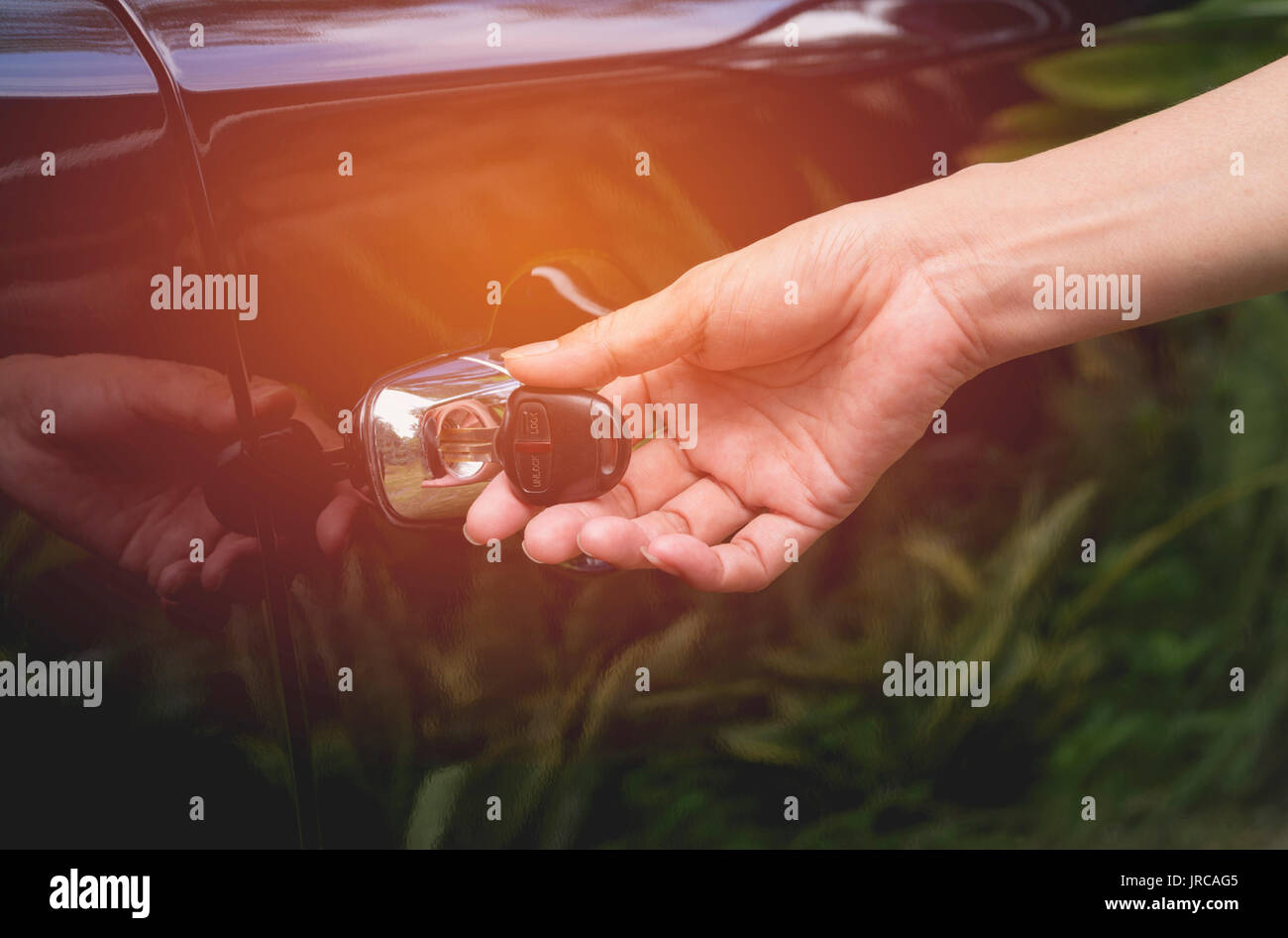 Close-up of woman opening a car door. Hand on handle. Female is opening a car. Stock Photo