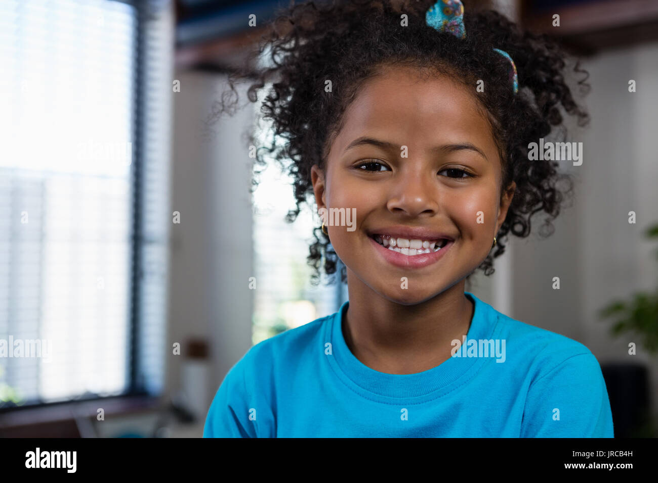 Portrait of smiling girl sitting on bed in clinic Stock Photo - Alamy