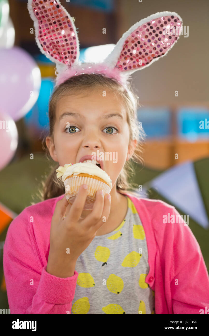 Birthday girl eating a cupcake at home Stock Photo