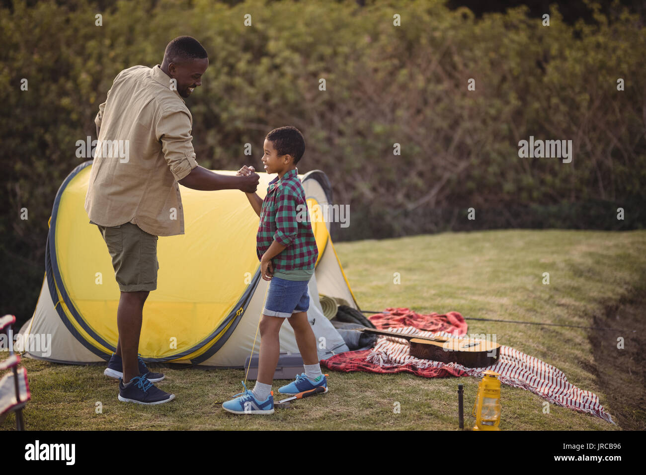 Smiling father and son shaking hands in park Stock Photo Alamy
