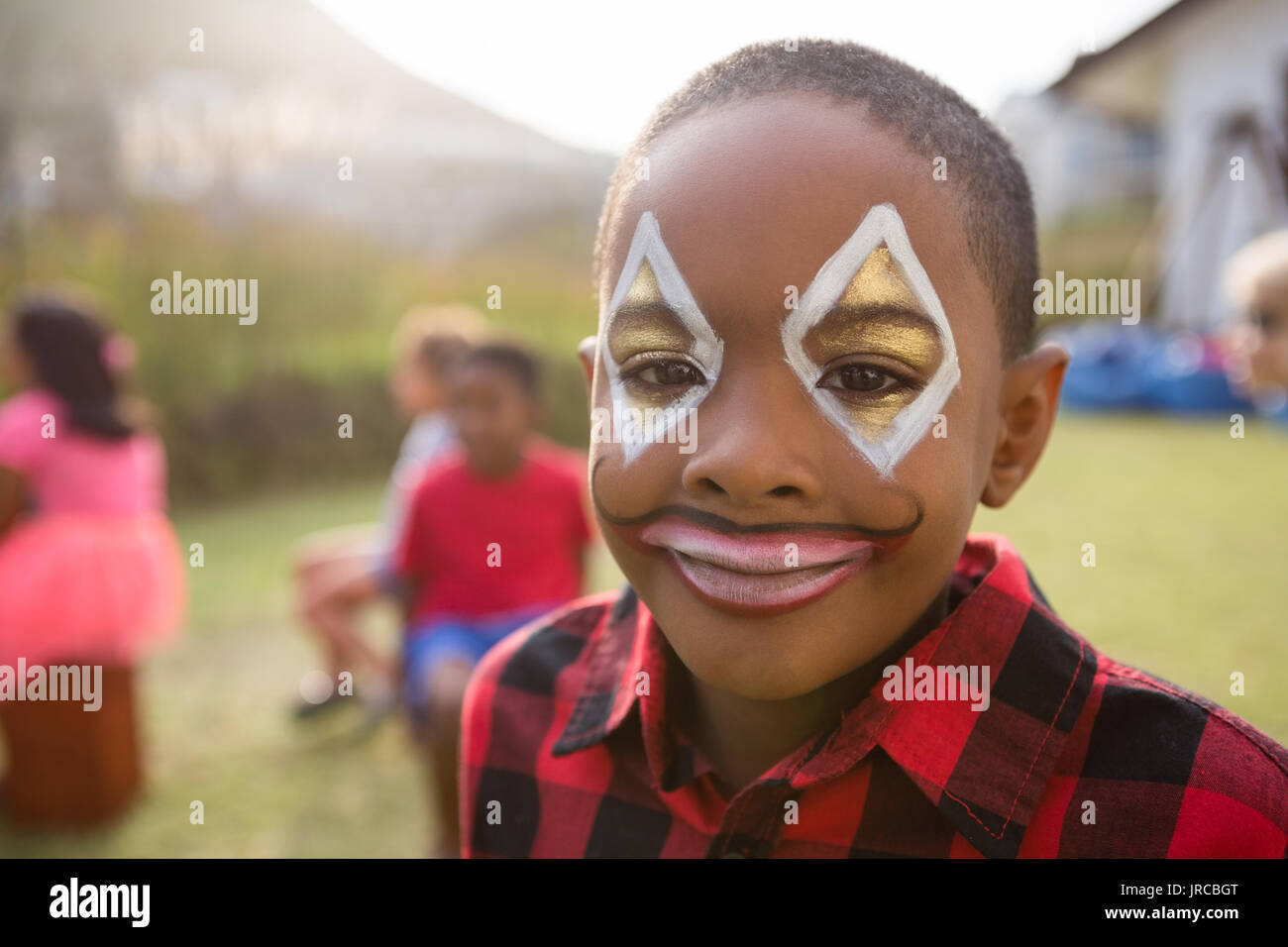 Close up portrait of boy with face paint standing in yard Stock Photo