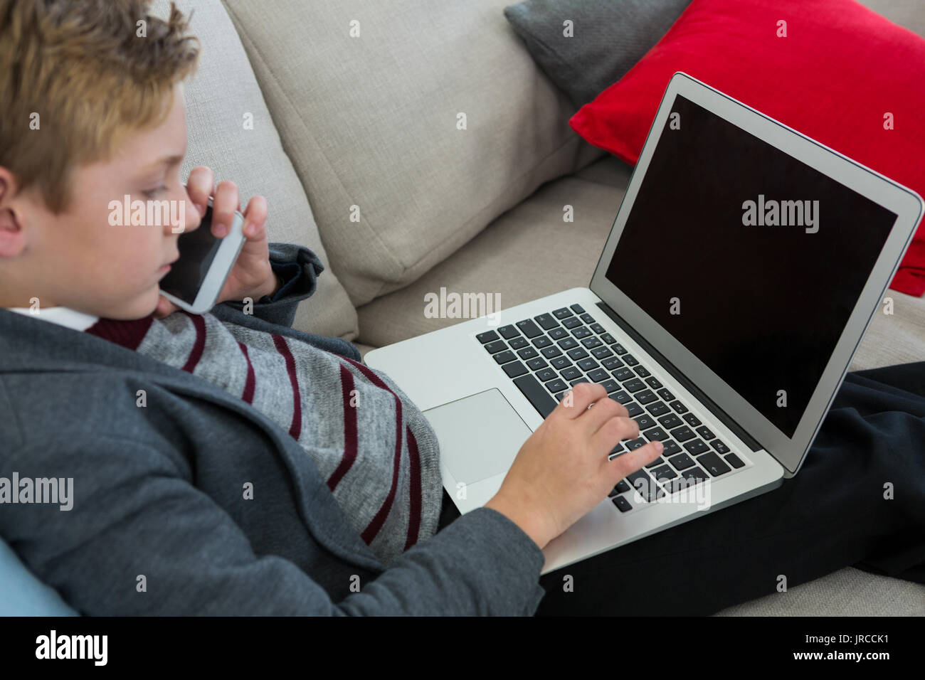 Little boy using laptop on couch Stock Photo - Alamy