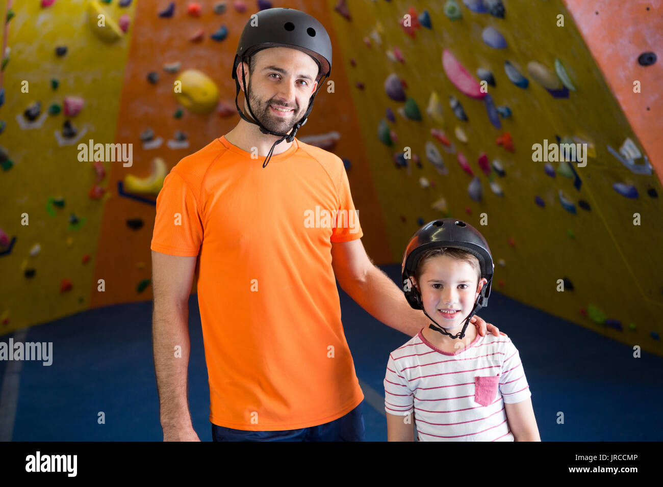 Portrait of happy trainer and kids standing in fitness studio Stock Photo