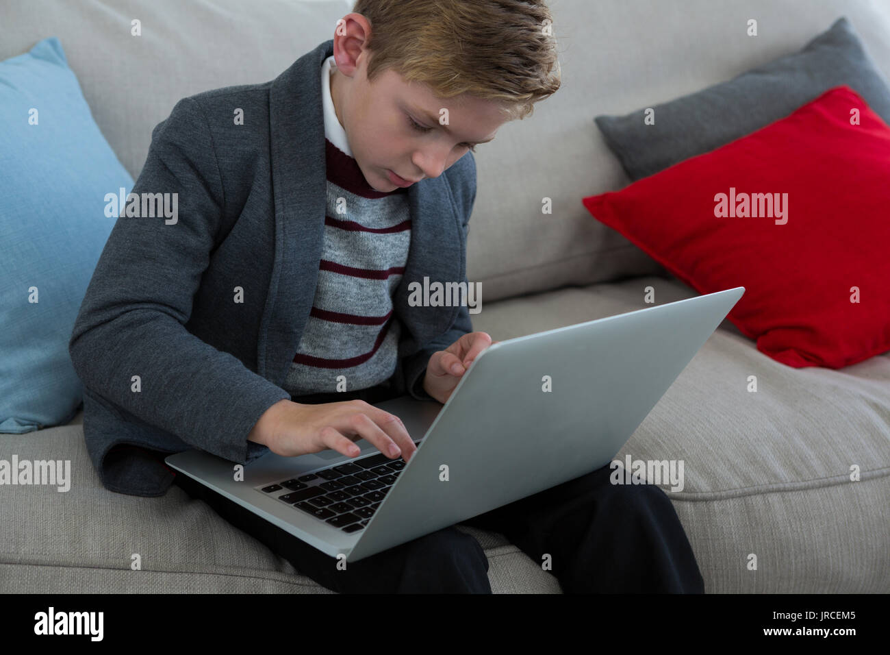 Little boy using laptop on couch Stock Photo - Alamy