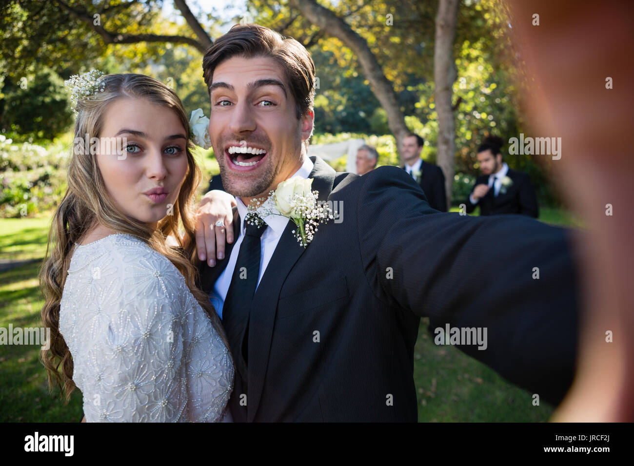 Portrait of happy couple posing in park during wedding Stock Photo - Alamy