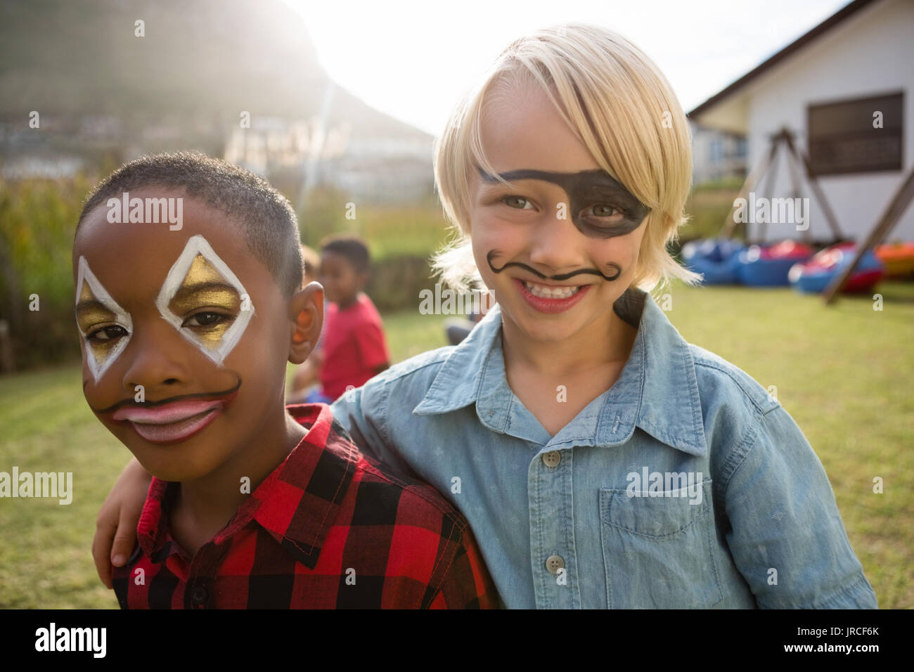 Portrait of boys with face paint standing in yard during birthday party Stock Photo