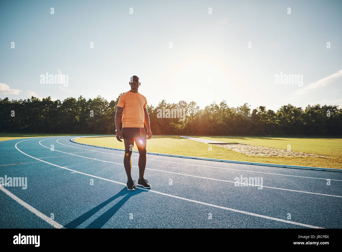 Focused young African male athlete in sportswear standing alone on a