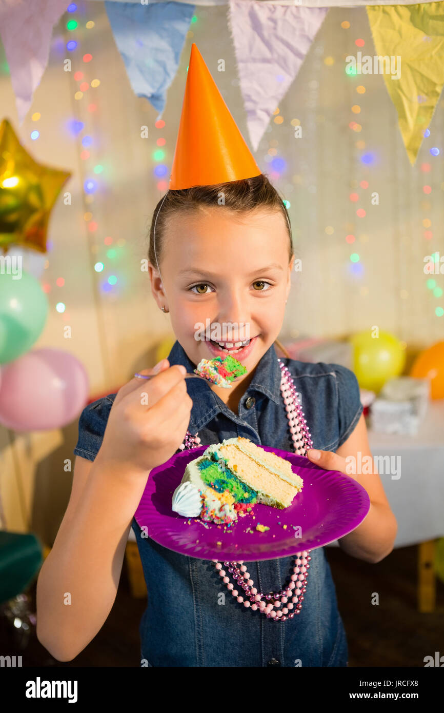 Portrait of girl eating cake during birthday party at home Stock Photo