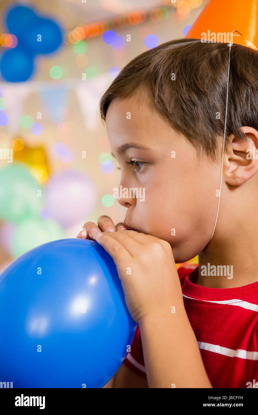 Cute boy blowing balloon during birthday party at home Stock Photo Alamy