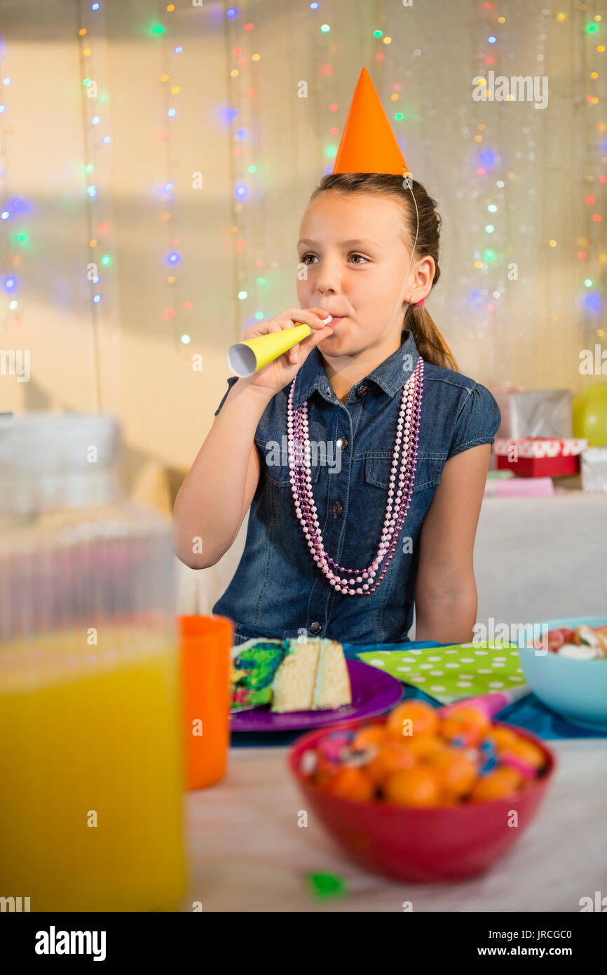 Girl blowing party horn during birthday party at home Stock Photo - Alamy