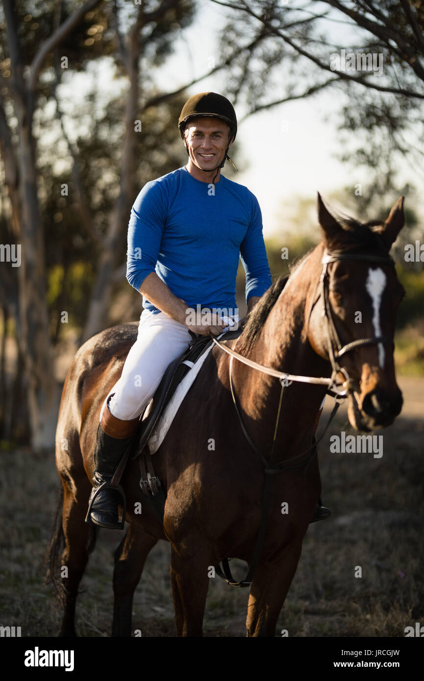 Portrait of confident male jockey riding horse Stock Photo