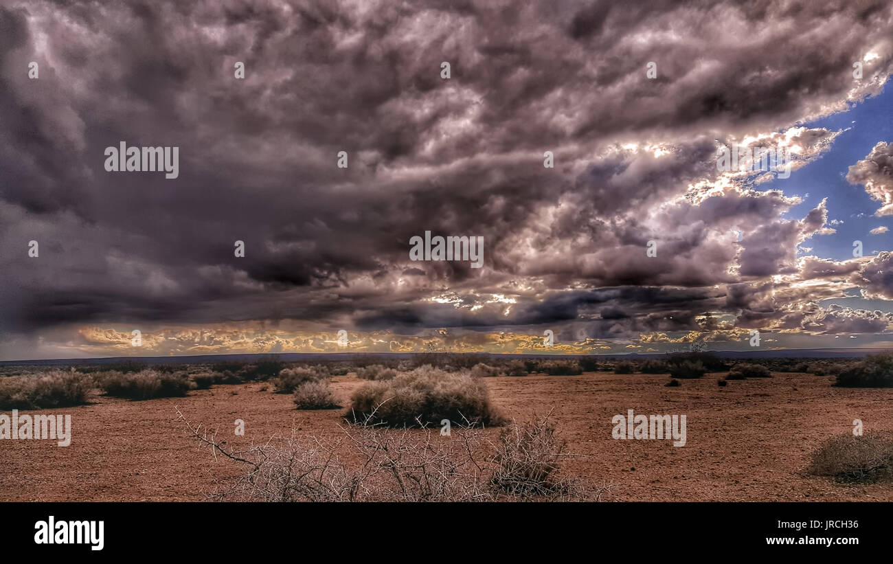 A stormy, ominous desert sky reveals a patch of blue. Stock Photo