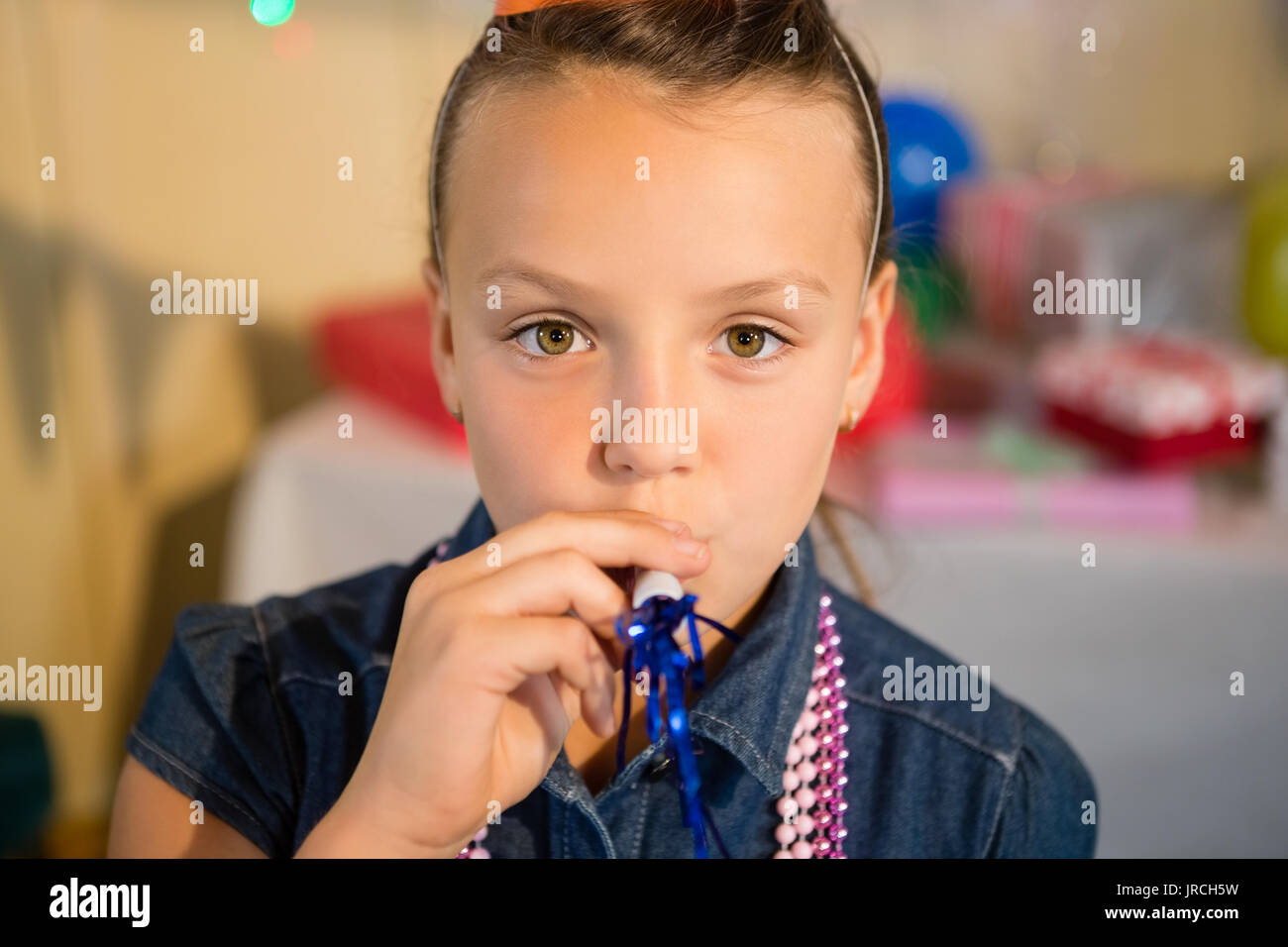 Girl blowing party horn during birthday party at home Stock Photo - Alamy