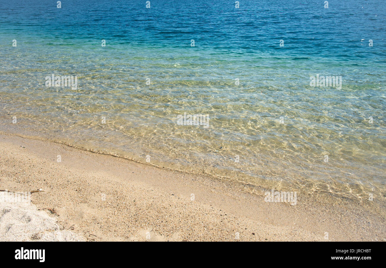 Clear blue calm Sea water background and sandy coast Stock Photo - Alamy