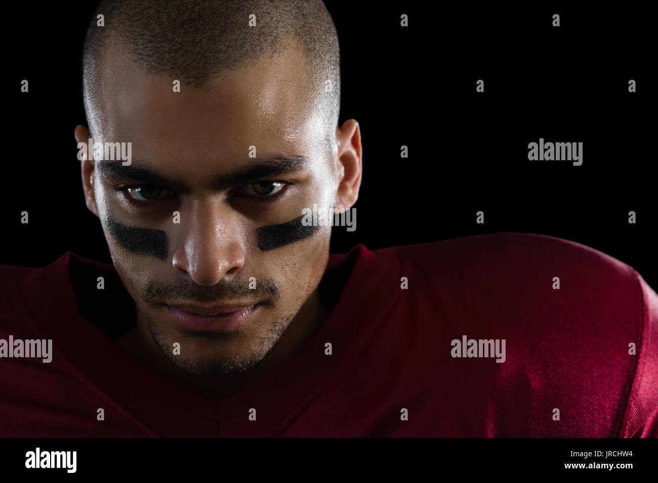 Portrait of determined American football player against a black background Stock Photo