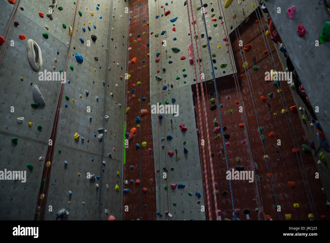 Low angle view of ropes hanging by climbing wall in gym Stock Photo