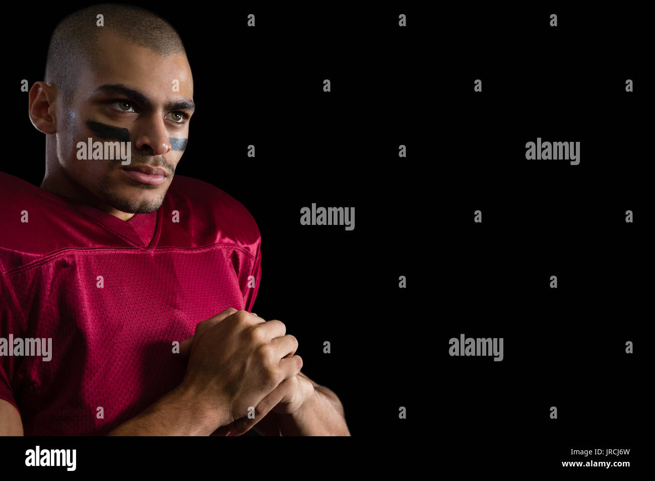 Close-up of determined American football player against a black background Stock Photo