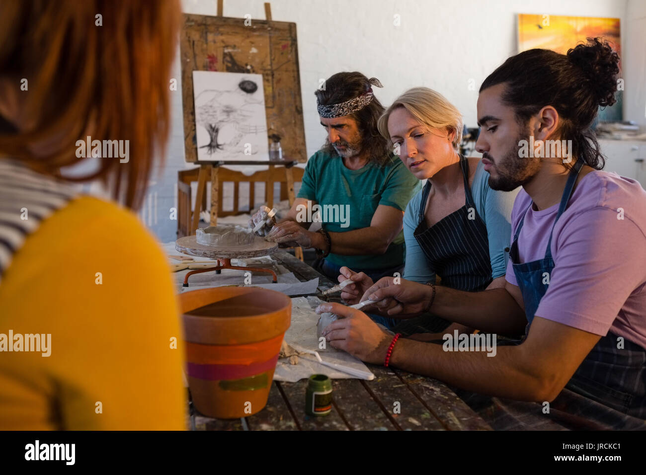 Teacher guiding students making clay products in art class Stock Photo