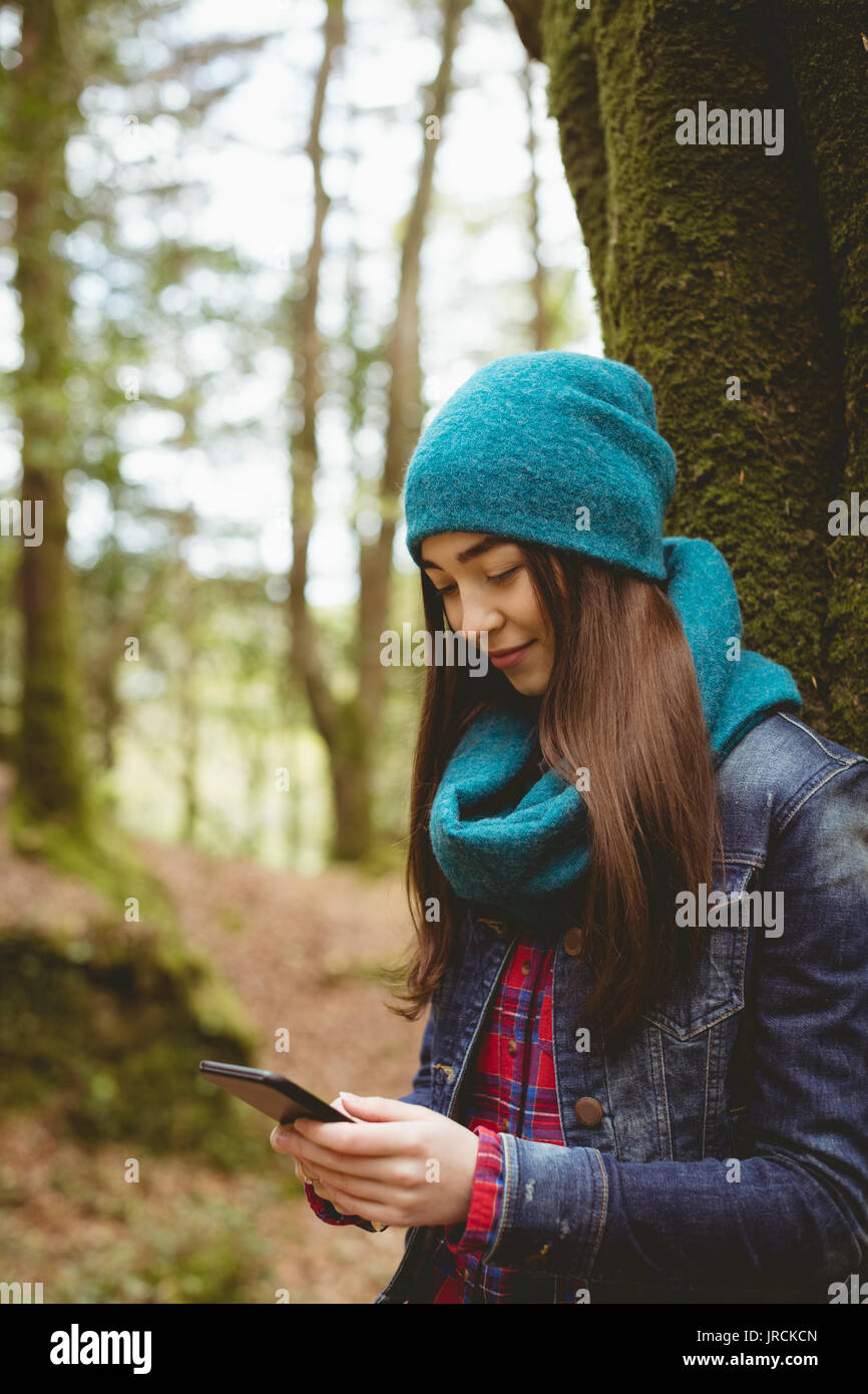Smiling woman using digital tablet in forest Stock Photo