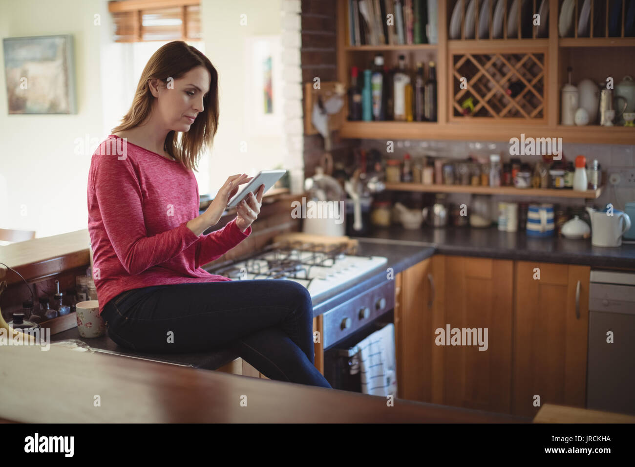 Woman using digital tablet in kitchen at home Stock Photo