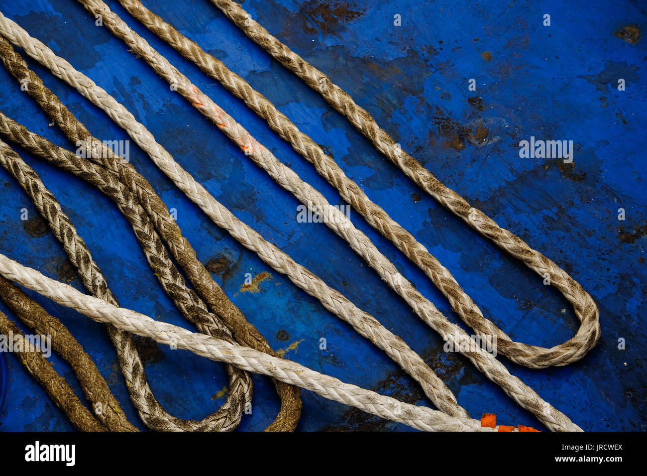 Dirty rope isolated on a blue background Stock Photo - Alamy