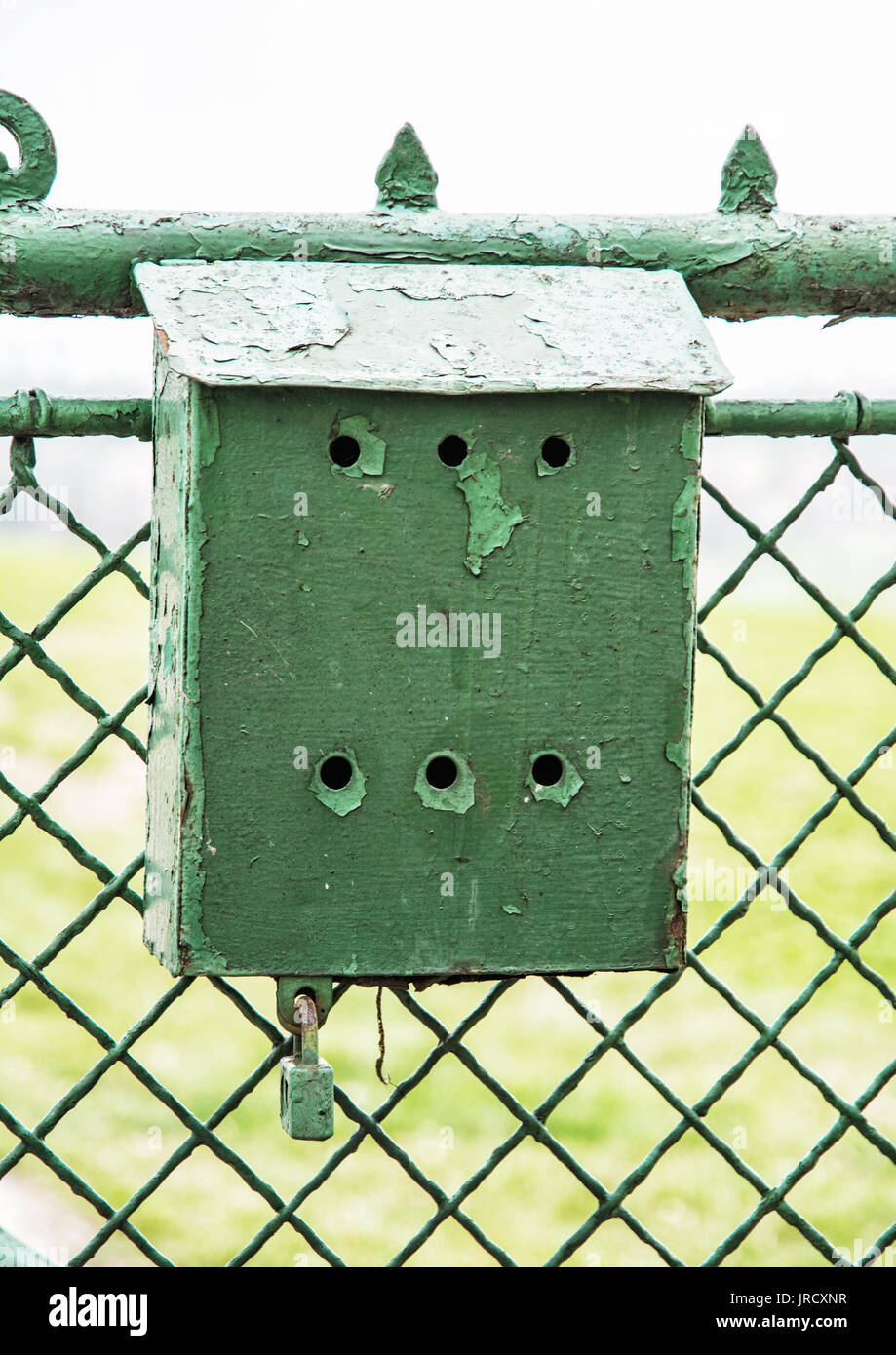 Old green metallic mailbox on the fence. Mail delivery. Stock Photo