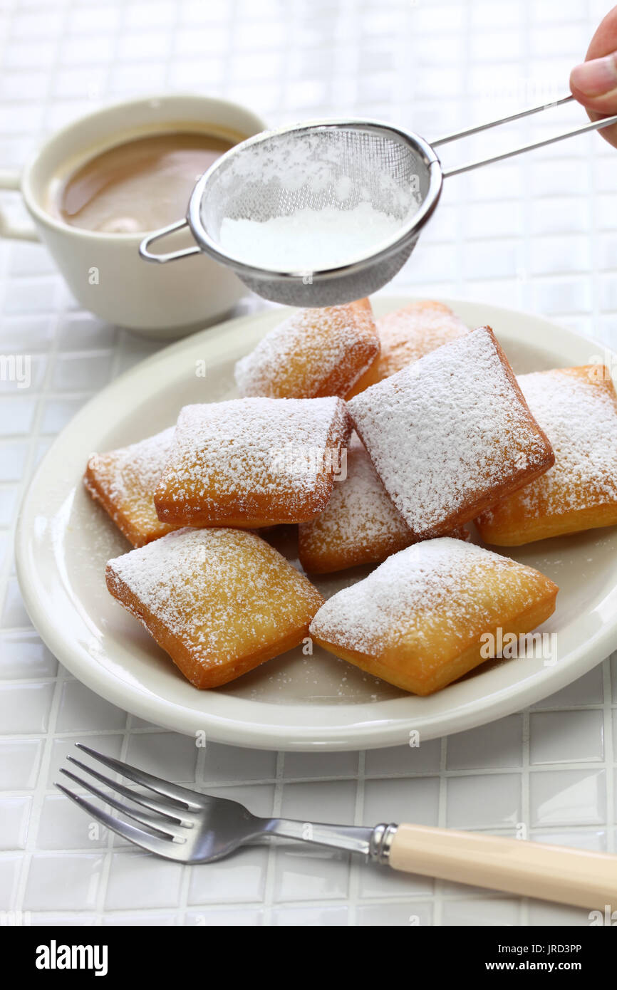 homemade new orleans donuts, sprinkle powdered sugar with sieve