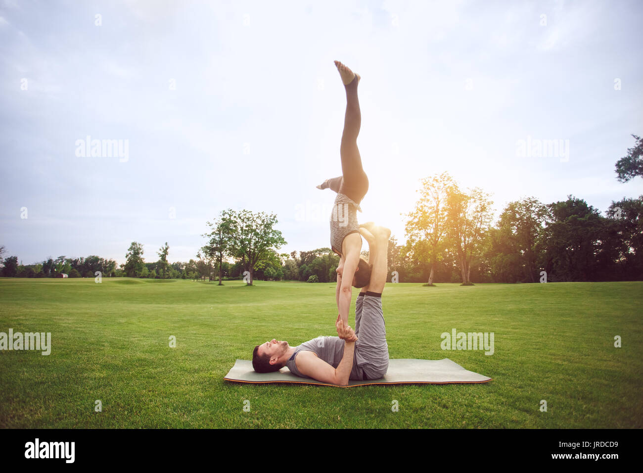 Man and woman practice acro yoga in the park Stock Photo
