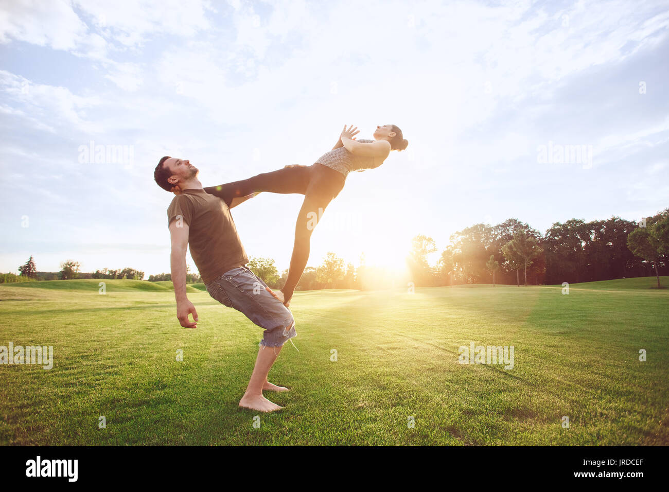 Man and woman practice acro yoga in the park Stock Photo