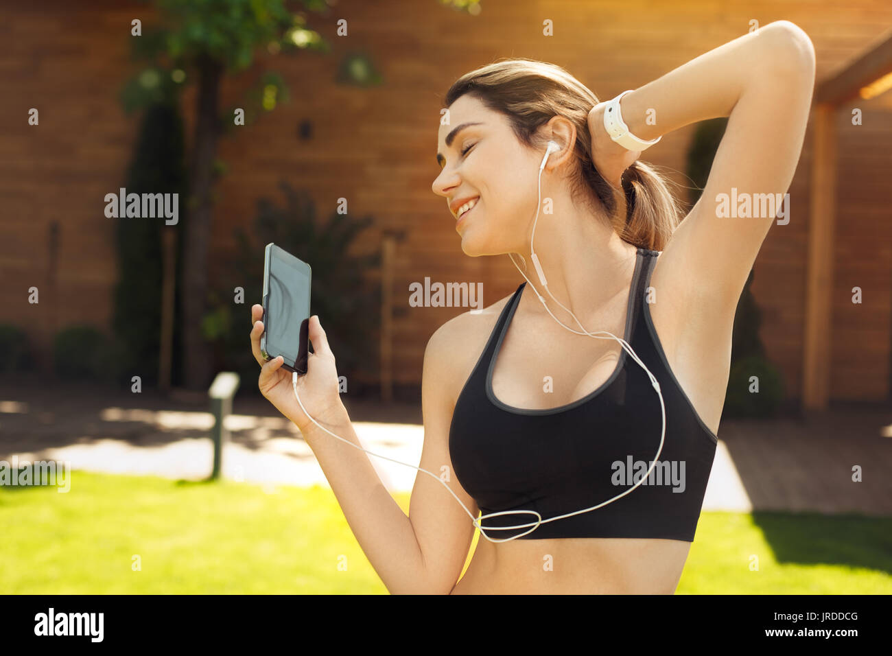 Young female exercise in the park listening music Stock Photo