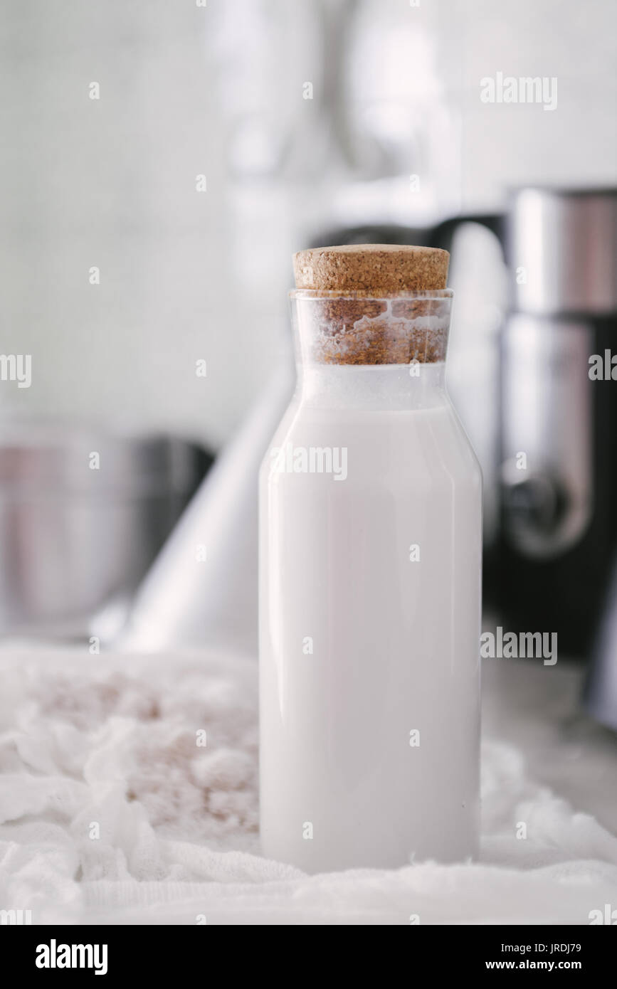 Homemade coconut milk in a bottle, mixed in a blender and pressed through a cotton sieve Stock Photo
