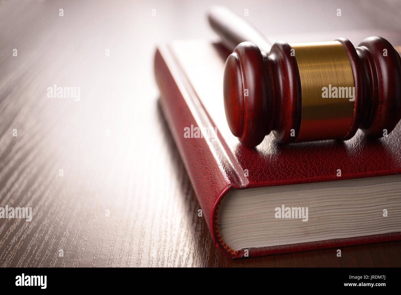 Wooden judges gavel lying on a law book in a courtroom for dispensing justice and sentencing crimes Stock Photo