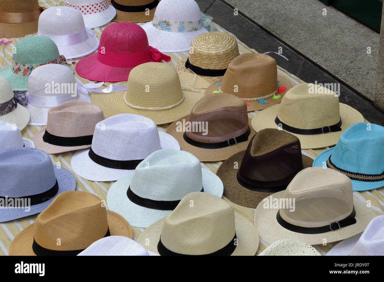 A close view of many Panama straw hats on a cotton sheet on sale on a street by a peddler Stock Photo