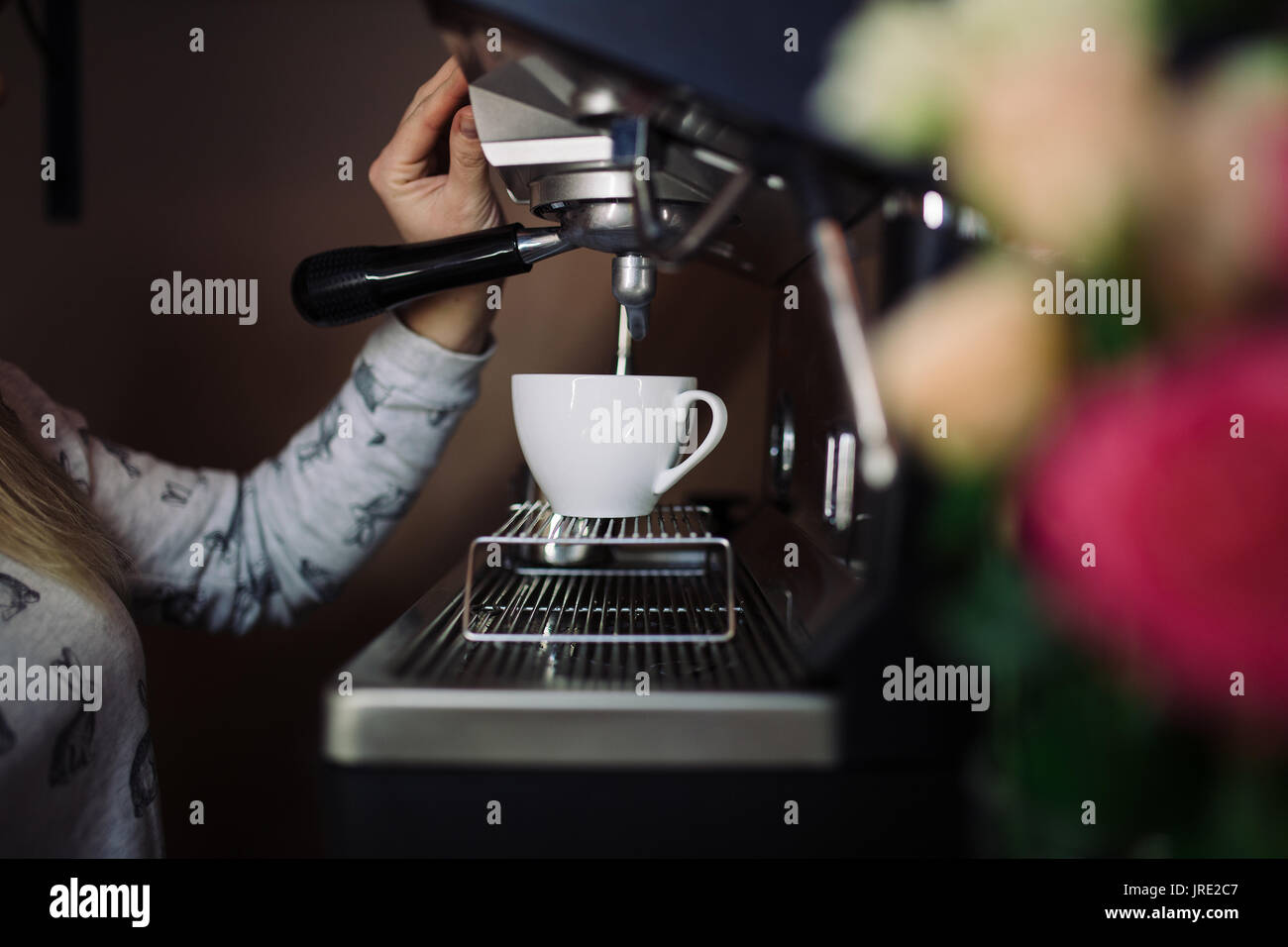 Coffee machine make espresso in cup. female barista preparing coffee in cafe Stock Photo