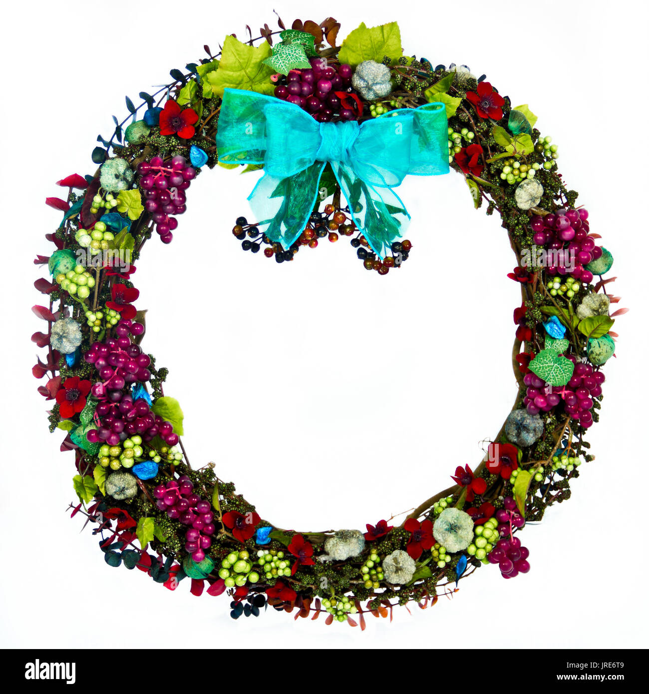 The decorations on a natural grapevine wreath are the colors of burgandy, pale  green, blue-green, blue-gray and dark blue and feature grapes, seeds,  Stock Photo