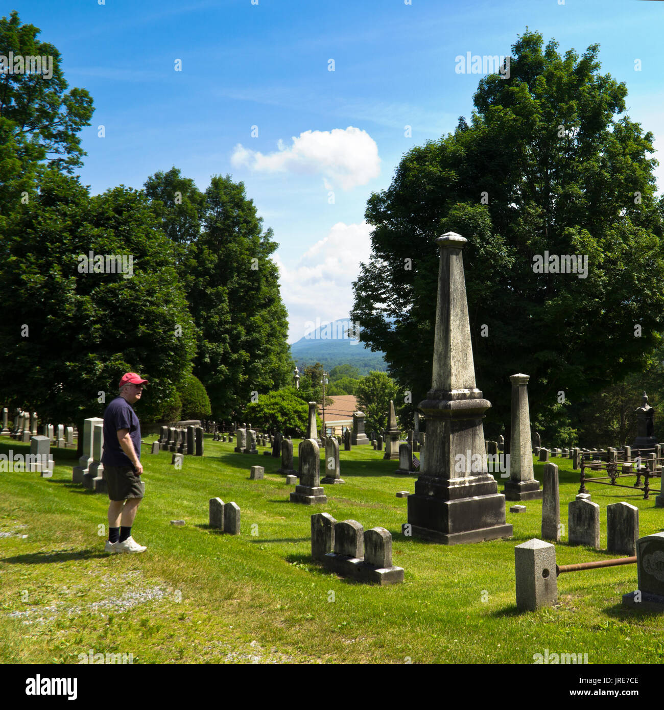 A man looks at the  cemetery of the  First Church of Old Bennington, Vermont, whose gravestones are from the Revolutionary War. Stock Photo