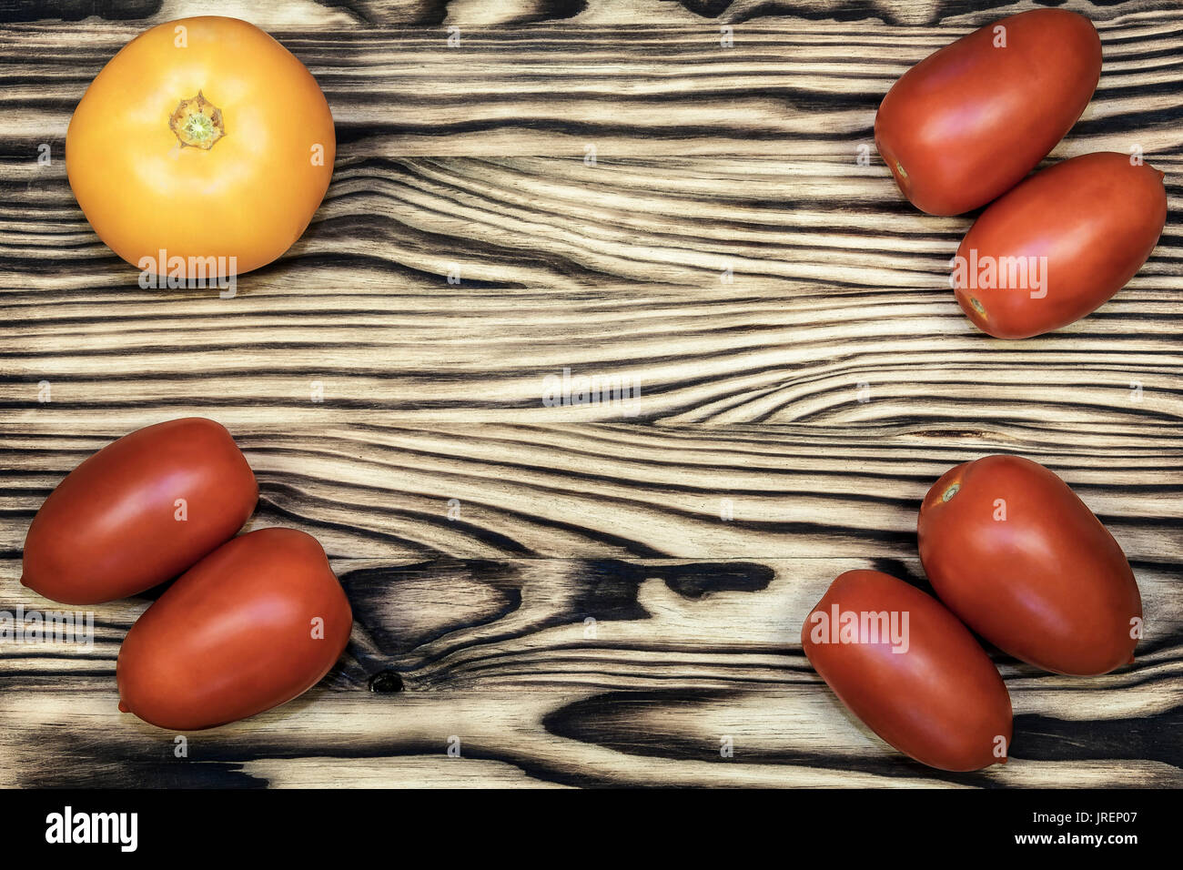 On the edges of the wooden surface are yellow and red tomatoes Stock ...