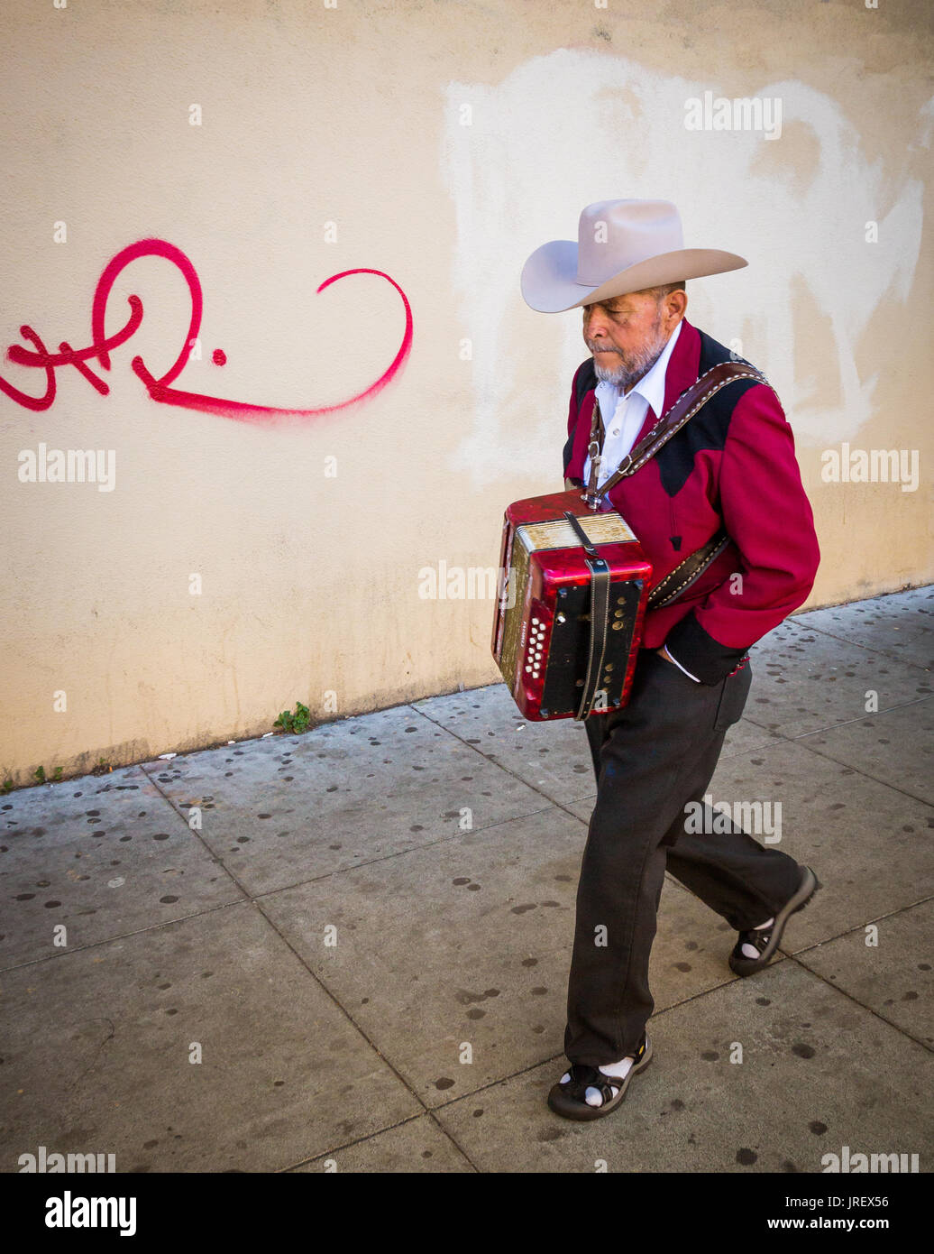 Accordion player walking along Mission Street in San Francisco, California. Stock Photo