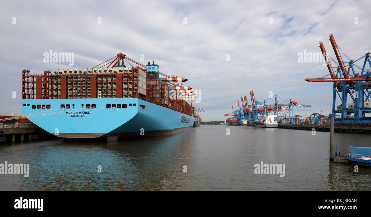 dpatop - The 'Munich Maersk' container ship of the Danish Maersk Line lying at anchor during its maiden voyage at the Eurogate Terminal in the harbour of Hamburg, Germany, 05 August 2017. The container behemoth can carry 20,568 standard containers (TEU) and is thus the largest container ship ever to call at Hamburg. The 'Munich Maersk' belongs to the second generation of the 'Triple E Class'. The three Es stand of Efficiency, Economy of Scale and Environment. They are among the most modern transport ships in the world. Photo: Christian Charisius/dpa Stock Photo