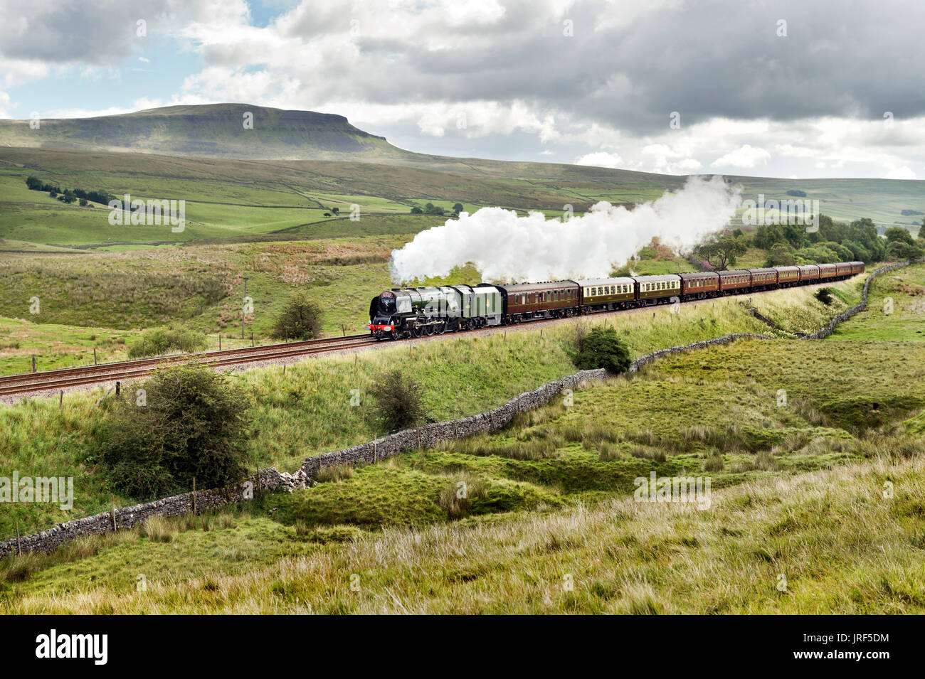 Horton-in-Ribblesdale, UK. 05th Aug, 2017. The Duchess of Sutherland steam locomotive hauls the Cumbrian Mountain Express special train through Ribblesdale in the Yorkshire Dales, on the scenic Settle-Carlisle railway near Horton-in-Ribblesdale. In the background is Pen-y-Ghent peak. Credit: John Bentley/Alamy Live News Stock Photo