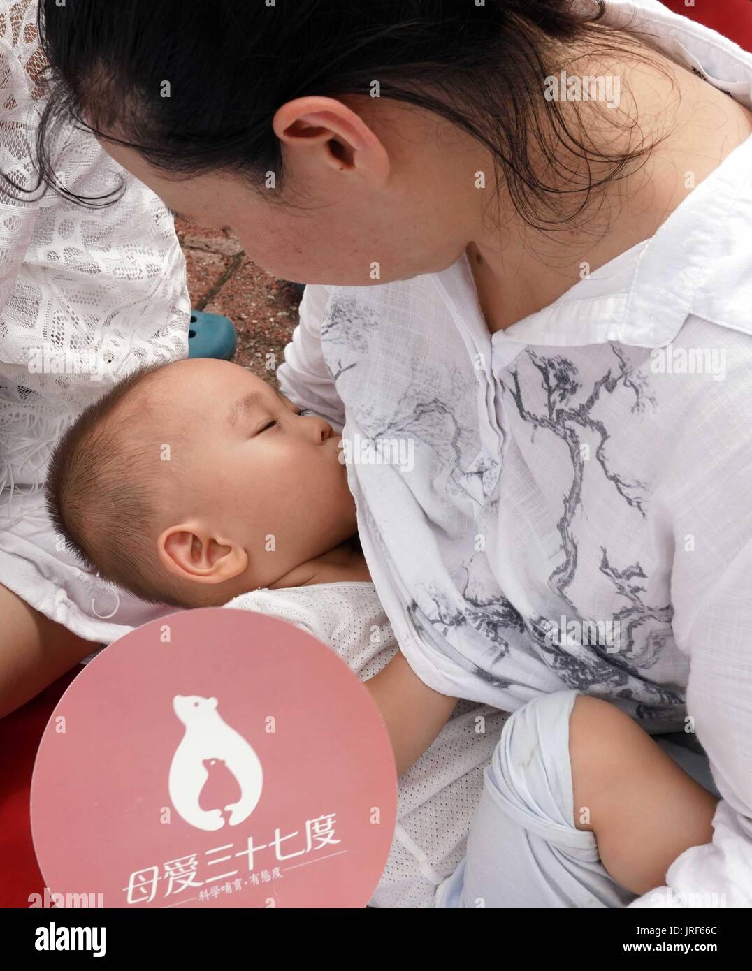 Beijing, China. 5th Aug, 2017. A mother breastfeeds her baby during an