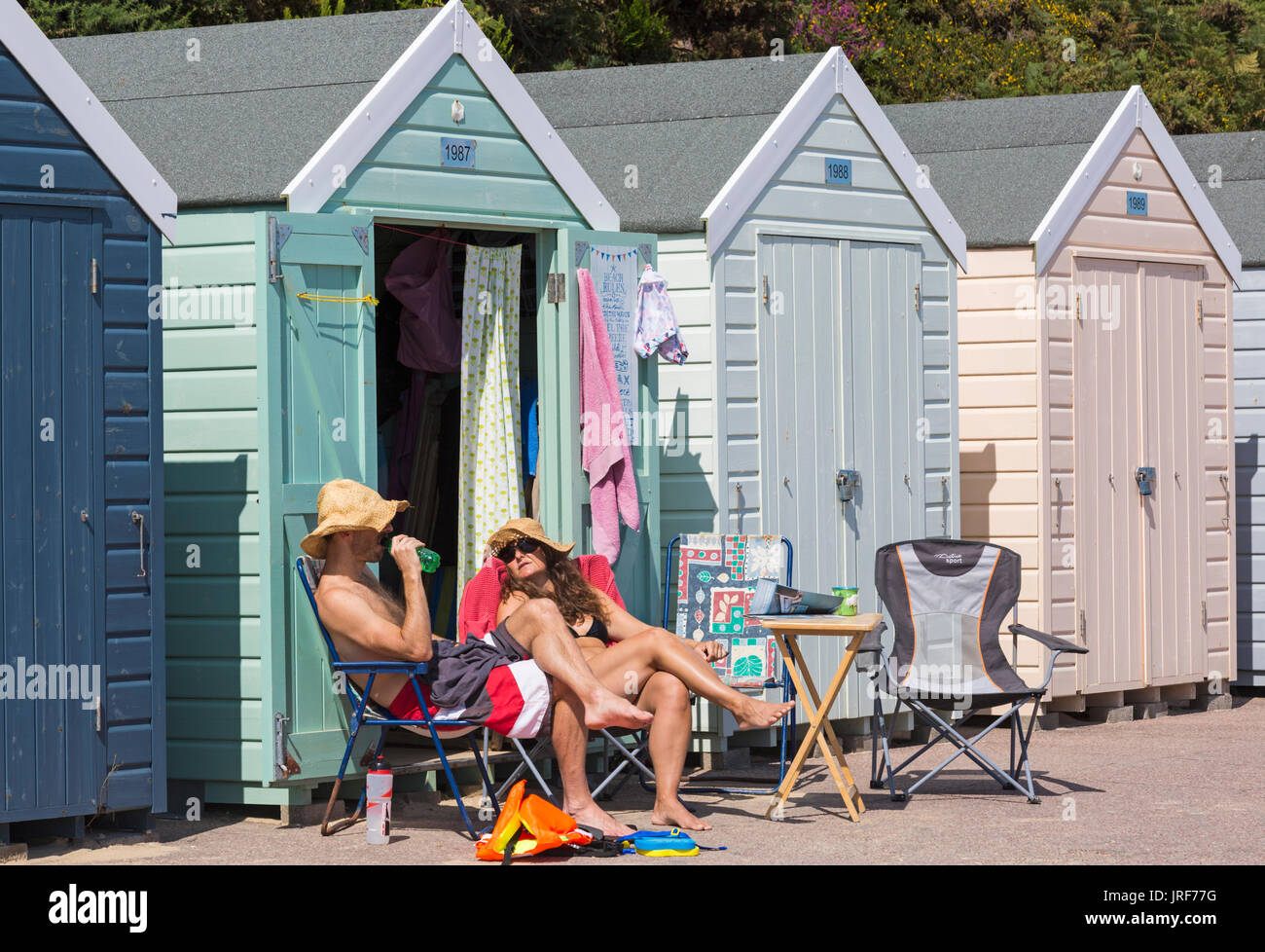 Bournemouth, Dorset, UK. 5th Aug, 2017. UK weather: nice warm sunny afternoon, as visitors head to the seaside to make the most of the sunshine at Alum Chine beach. Couple relaxing outside beach huts enjoying the sunshine. Credit: Carolyn Jenkins/Alamy Live News Stock Photo