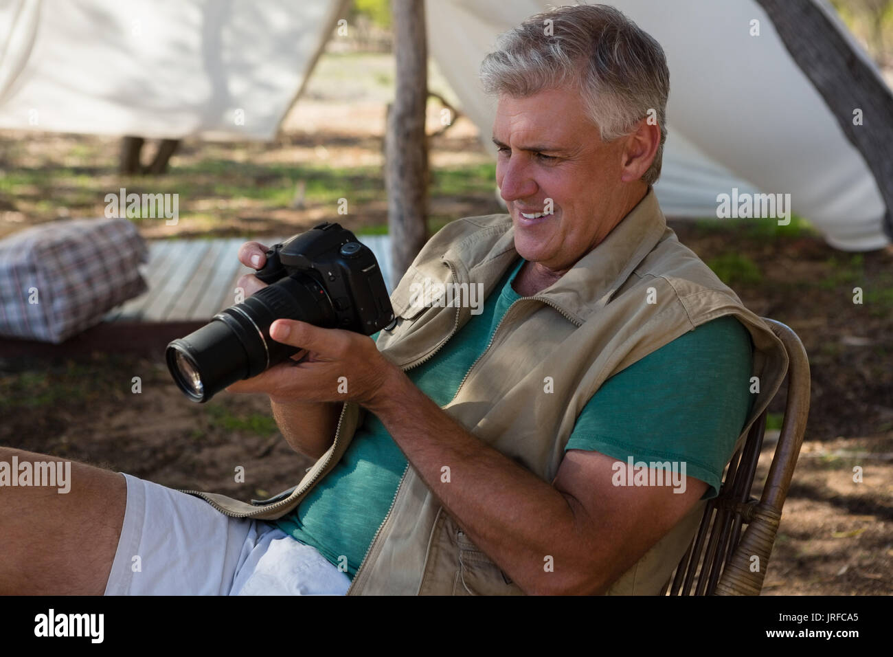 Man looking into camera outside tent Stock Photo