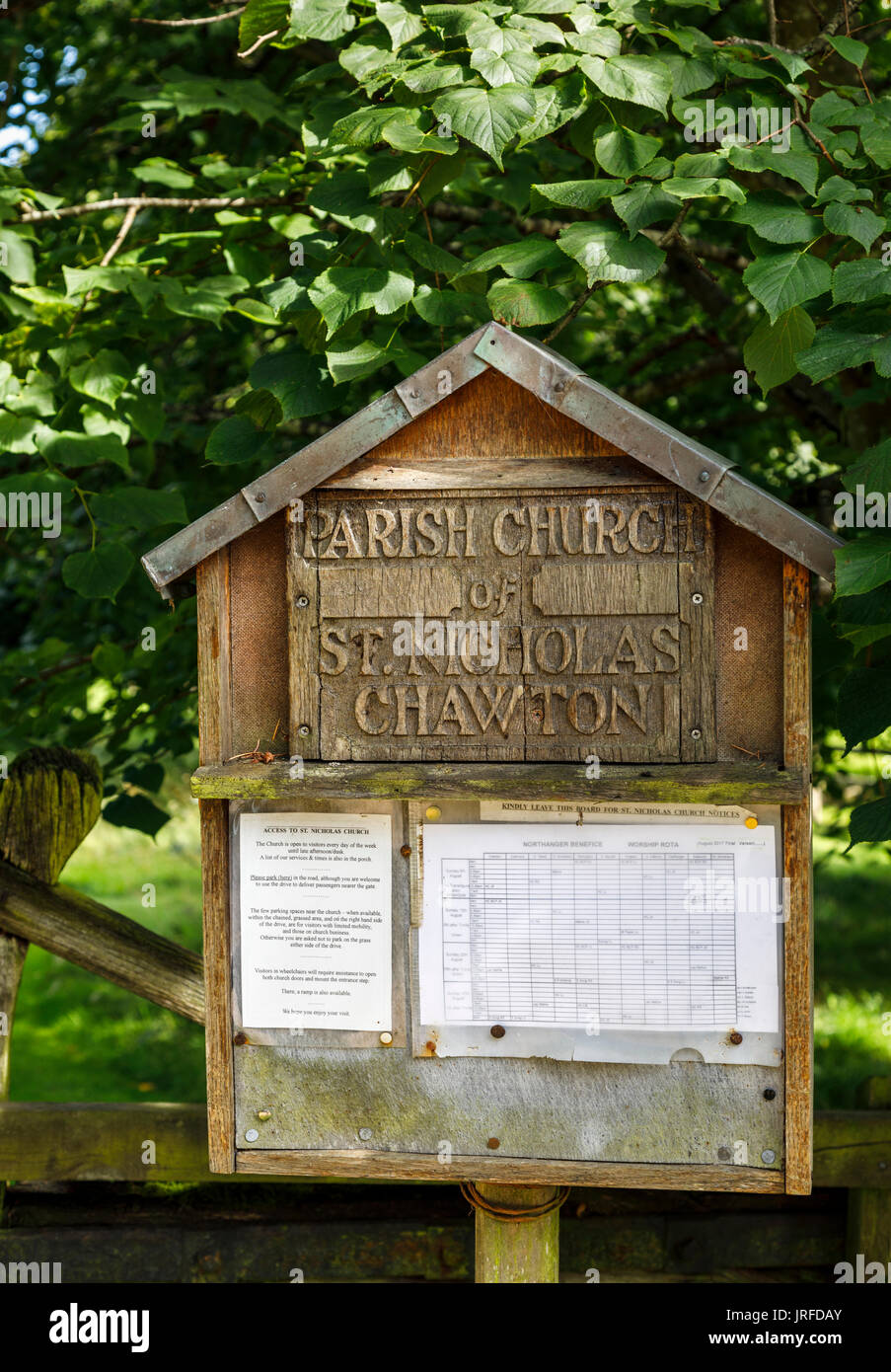 Wooden notice board outside Parish Church of St Nicholas, Chawton, Hampshire, southern England, UK, burial place of Jane Austen's mother and sister Stock Photo